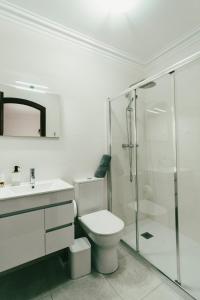 a white bathroom with a toilet and a shower at Casa de Férias da Costinha in Alijó