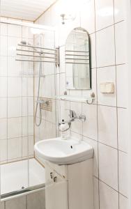 a white bathroom with a sink and a shower at Domek w Dąbrowie in Wielogłowy