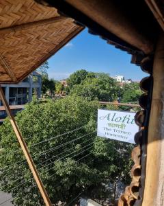 a sign for a restaurant with a view of a tree at Alohi The terrace Homestay in Tezpur