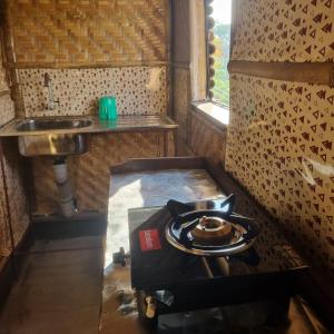 una pequeña cocina con fogones y fregadero en Alohi The terrace Homestay en Tezpur