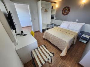 niewielka sypialnia z łóżkiem i krzesłem w obiekcie Vincenzo Hotel w mieście São Vicente de Minas