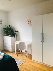 a bedroom with a desk and a white cabinet at 20 min to central London- 2 bedrooms apartment in London