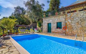 a swimming pool in front of a stone house at Villa Melissa Paxos in Bogdanátika