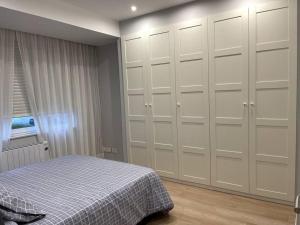 a bedroom with white cabinets and a bed at Piso en el centro de Ferrol recién reformado. in Ferrol