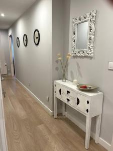 フェロルにあるPiso en el centro de Ferrol recién reformado.の白いドレッサーと鏡が備わる白い部屋 +3枚の写真