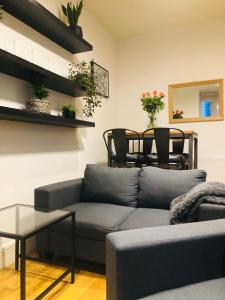 a living room with a couch and a table at 20 min to central London- 2 bedrooms apartment in London