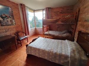 a bedroom with two bunk beds and a window at Bed&Breakfast - Mirador de San Marcos in Paipa