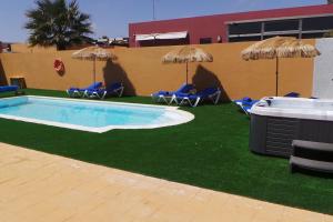 a swimming pool with chairs and umbrellas at Luxury Villa at Golf Course in Costa de Antigua