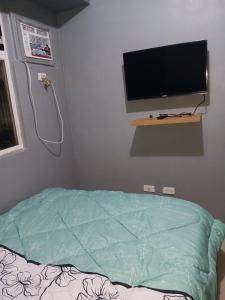 een ziekenhuiskamer met een bed en een flatscreen-tv bij K2K place in Manilla