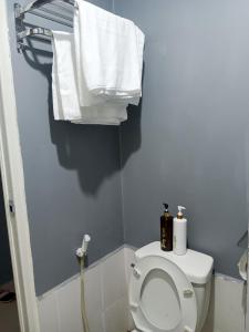 a bathroom with a toilet with towels on the wall at K2K place in Manila