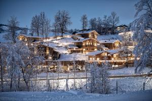 a home covered in snow at night at Pool Luxury Lodge in Wagrain