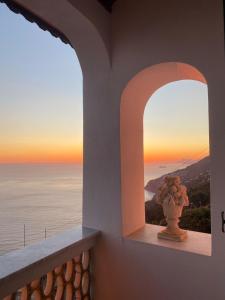 a vase on a window sill with a view of the ocean at Casa Barbara in Amalfi