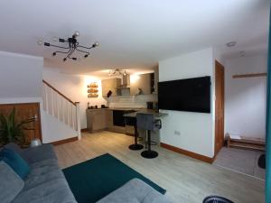 sala de estar con sofá y cocina en Entire modern cottage close to beach - Pet friendly en Gosport