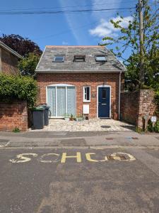 a brick house with a blue door on a street at Entire modern cottage close to beach - Pet friendly in Gosport