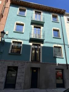 un edificio azul con ventanas y una puerta en Ático abuhardillado imak Jaca, en Jaca