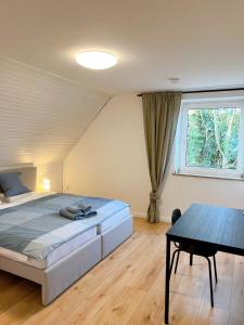 a bedroom with a bed and a table and a window at Haus Neuss-2OG in Neuss