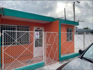 een oranje en groen gebouw met een poort bij Middle East House in Mérida