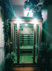 een voordeur met verlichting in een kamer met planten bij Maison ZEN avec Sauna in Ronchin
