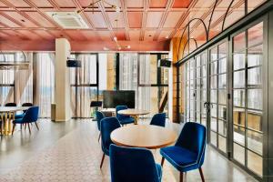 a meeting room with tables and chairs and windows at Scarletz Suites KLCC by M Suites in Kuala Lumpur