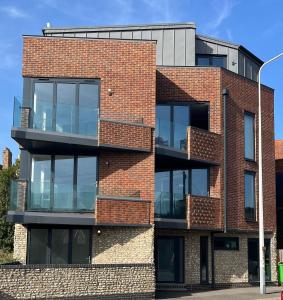 a red brick building with glass balconies at Stunning Luxury 3 Bed Penthouse Sleeps 2 to 6 in Hythe