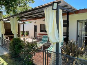 科洛尼亞－德爾薩克拉門托的住宿－Magnolio，庭院设有遮阳篷、椅子和桌子