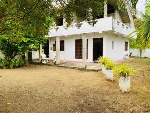 a white house with plants in front of it at Wishwa Villa in Weligama