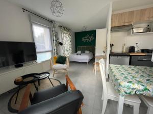 a kitchen and a living room with a couch and a table at Minimes, Studio Cosy Tout Confort, Wifi, Parking in Toulouse