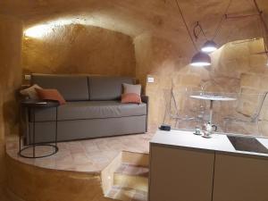 uma sala de estar com um sofá e uma mesa em Suite San Biagio nei sassi em Matera