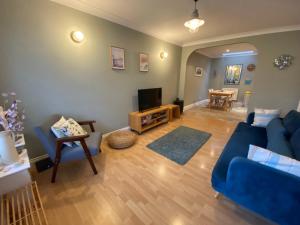 a living room with a blue couch and a television at Harbour Mews Central Location Near Beach in Whitstable