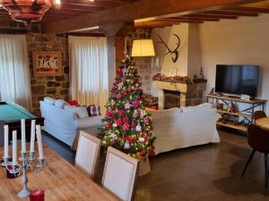 a christmas tree in the middle of a living room at FORJAS DE ORZALES in Orzales