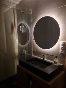 baño con lavabo y espejo grande en Wilaya Center Suites, en Tetuán