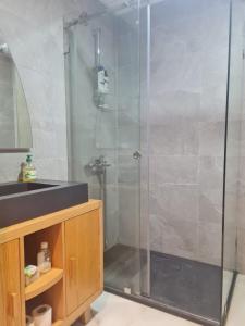 y baño con ducha acristalada y lavamanos. en Wilaya Center Suites, en Tetuán