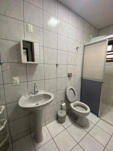 y baño con lavabo, aseo y espejo. en Casa em Bombinhas Próximo a Praia, en Bombinhas