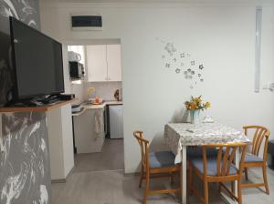 a kitchen and dining room with a table and chairs at Csilla Apartman in Balogunyom