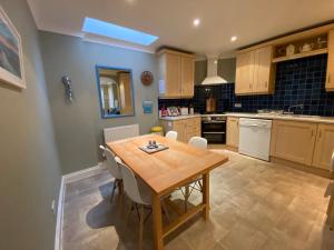 a kitchen with a wooden table and chairs at Harbour Mews Central Location Near Beach in Whitstable