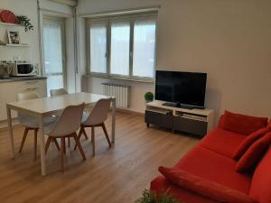 sala de estar con mesa y sofá rojo en Cornelia IDI Gemelli, Chicca Metro Apartment, en Roma
