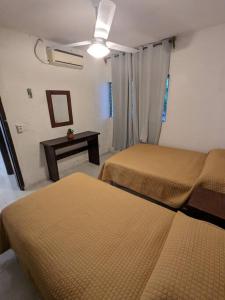 a hotel room with two beds and a table at Dpto. a unos pasos de la playa en Las Brisas in Manzanillo