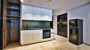 a kitchen with white cabinets and a black refrigerator at NordOst fineliving in Ischgl