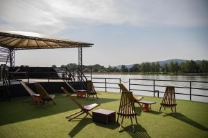 a group of chairs and an umbrella on the deck of a boat at Boatel Copacabana in Veliko Gradište