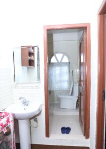 y baño con lavabo, aseo y espejo. en FamilyHome, en Katmandú