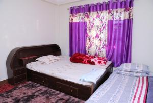 1 dormitorio pequeño con cortinas moradas y 1 cama en FamilyHome, en Katmandú