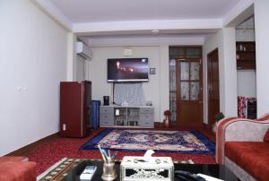 sala de estar con sofá y TV en FamilyHome, en Katmandú
