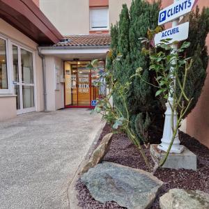 a street sign in front of a building at Kyriad Direct Limoges Nord in Limoges