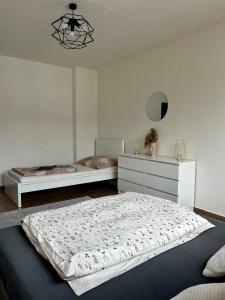een witte slaapkamer met 2 bedden en een kroonluchter bij Apartment Lilly in Špindlerův Mlýn