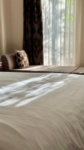 a close up of a white bed with a window at Alseides Boutique Hotel in Elatochori