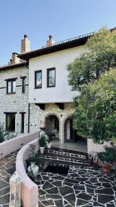 une maison avec un bâtiment en pierre et une cour en pierre dans l'établissement Alseides Boutique Hotel, à Elatochori