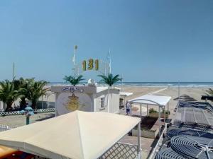 a building with a clock on it next to the beach at Hotel Laura Beach in Rimini