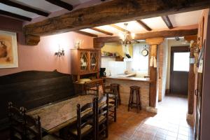 a dining room with a table and a kitchen at Casa Rural Los Arrieros in La Puerta