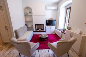 ein Wohnzimmer mit einem Sofa, Stühlen und einem TV in der Unterkunft Ιkia Zmas in Argalasti