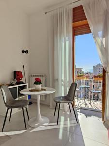a living room with a table and chairs and a balcony at Oasi al centro con parcheggio in Salerno
